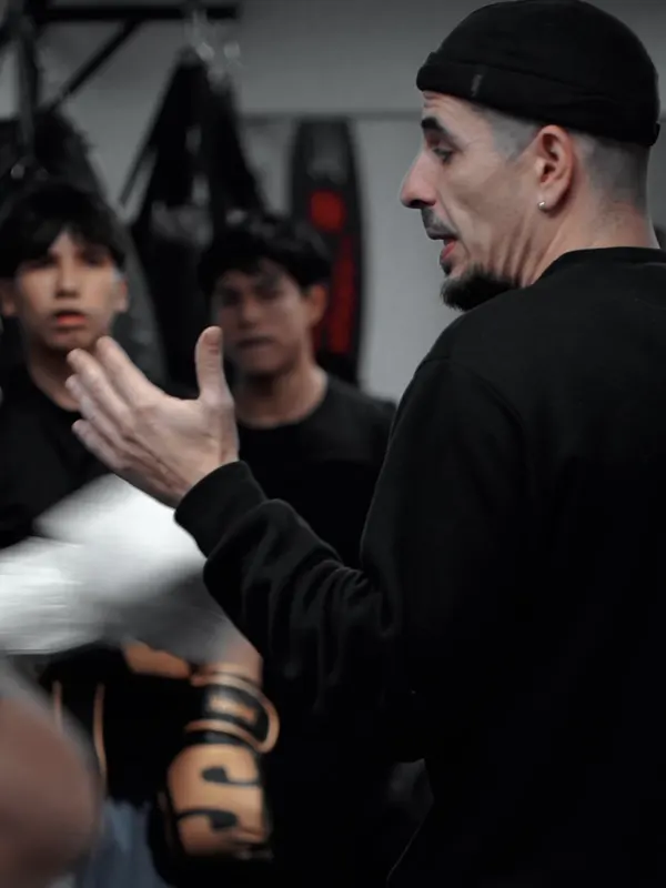 El entrenador explica un golpe a los alumnos en el club de boxeo.