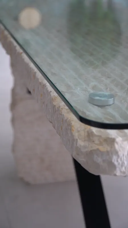 Canto de piedra natural tallada a mano bajo un sobre de cristal.